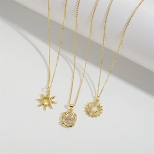 Ensemble de colliers dorés avec pendentifs soleil et croix sertis de zircons