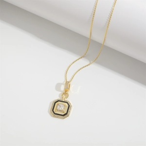 Vue détaillée d'un pendentif octogonal doré avec émail noir et cristaux de zircon micro-sertis