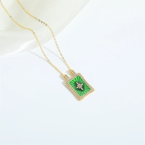 Détail d'un pendentif rectangulaire doré avec émail vert et motif d'étoile en zirconiums