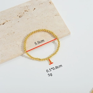 Elegant gold beaded bracelet with letter A pendant on light stone background