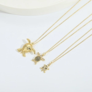 Three gold sea turtle pendants with sparkling zircon stones on matching fine O-chains