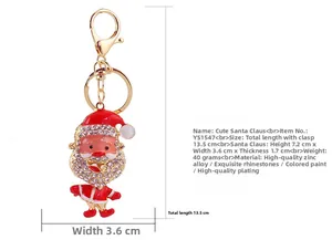 Close-up of golden Santa Claus keychain with sparkling rhinestones and red paint finish