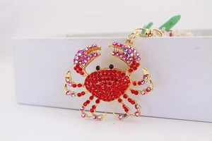 Vue rapprochée du porte-clés crabe mignon orné de strass rouges et métal doré brillant