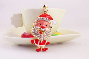Detail of Santa Claus keychain with rhinestones hanging on a white coffee cup