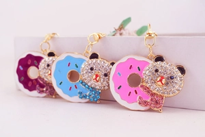 Close-up of three sparkling rhinestone bear donut keychains in pink, blue and purple