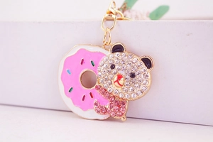 Macro shot of bear keychain encrusted with pink rhinestones on a colorful donut
