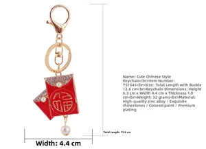 Detail of red Chinese Fu charm keychain with gold metal frame and pearl pendant