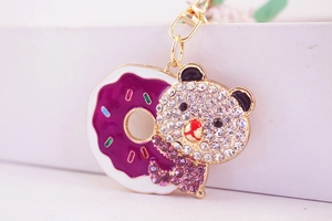 Macro detail of golden bear donut keychain with purple rhinestones and enamel finish