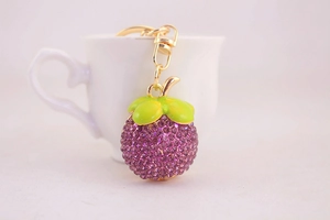 Détail macro du porte-clés mangoustan avec strass violets et fermoir mousqueton