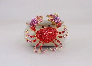 Vue macro d'un porte-clés crabe doré orné de strass rouges et irisés étincelants