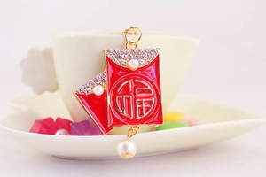 Close-up of red enamel Fu pendant with luxury pearls and sparkling rhinestones
