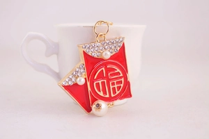 Detailed view of Chinese red envelope keychain with pearls and crystals on a white cup