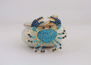 Gros plan détaillé d'un porte-clés crabe avec strass bleu ciel sur base en alliage doré