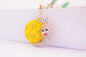 Détail du porte-clés escargot jaune avec strass en cristal et fermoir doré brillant