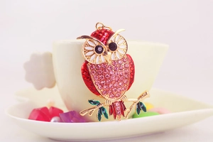 Details vom Eulen Schlüsselanhänger mit rosa Kristallen und Emaille Blättern
