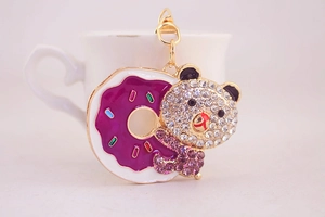 Detail der Strass-Bären-Schlüsselanhänger mit lila Donut und goldenem Metallhaken