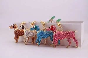 Close-up of four colorful rhinestone-encrusted dog keychains in gold alloy frame