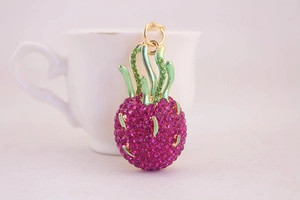 Close-up of dragon fruit keychain with pink rhinestones and green enamel leaves