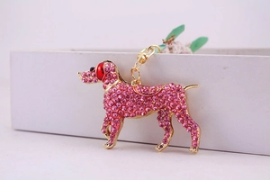 Detailed side view of pink rhinestone puppy keychain with gold lobster clasp for bags