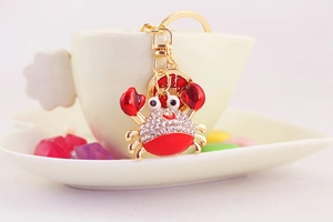 Macro shot of crab keychain with white crystals and red enamel detailing