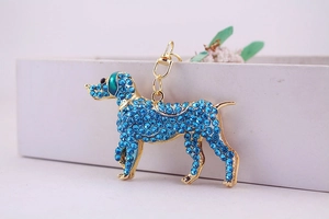 Detailed macro view of gold metal puppy keychain encrusted with blue rhinestones