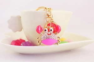 Detailed macro of a cute crab keychain with pink enamel and sparkling crystals
