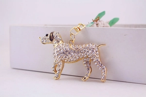 Detail view of a gold dog keychain encrusted with crystals and a lobster clasp hook