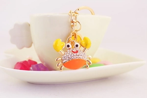 Close-up of cute crab keychain with sparkling rhinestones and orange enamel finish