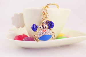 Detail of crab keychain with blue enamel, white rhinestones and lucky coin charm
