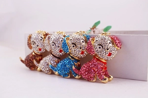 Detail view of four crystal-encrusted puppy keychains in brown silver blue and pink colors