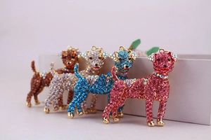 Macro shot of cute puppy keychains with colorful rhinestones on a minimalist white box