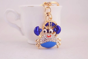 Close-up of blue crab keychain with sparkling rhinestones on a white coffee cup