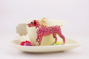 Detail shot of the pink rhinestone shepherd dog keychain hanging on a white coffee cup