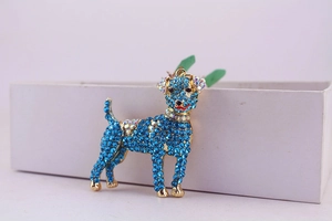 Close-up of golden dog keychain with sky blue rhinestones and sparkling crystal details