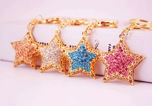 Detail showing four colors of sparkling rhinestone star keychains in gold and silver finish