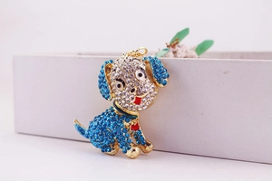 Close-up of blue and white rhinestone encrusted dog keychain on a gold metal base