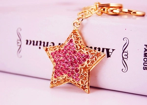 Detailed macro view of the gold hollow star keychain with sparkling pink rhinestones