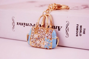 Macro view of blue enamel handbag keychain with sparkling rhinestones and gold alloy ring