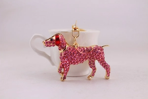 Detail view of pink rhinestone dog keychain with gold metal frame and D-ring clasp