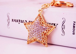 Detail shot of golden star keychain with purple rhinestones and hollow-out metal stars