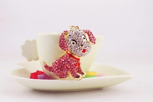 Detailed view of a cute puppy keychain with pink and white rhinestones in a heart dish