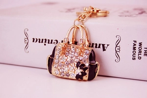 Detail of a luxury handbag keychain with sparkling rhinestones and floral enamel finish