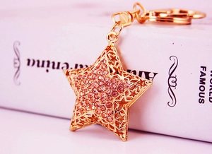 Macro shot of gold star keychain featuring pink rhinestones and elegant lobster clasp