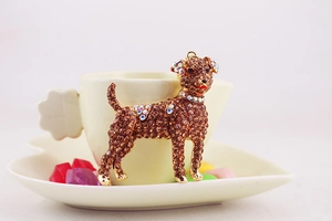 Close-up of cute dog keychain featuring brown and colorful rhinestones on a coffee cup