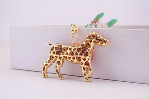Detail of golden puppy keychain with pink rhinestones and heart cutouts for handbags