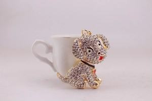 Close-up of golden puppy keychain with white rhinestones and a red enamel tongue detail