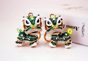Détails de deux porte-clés danse du lion vert et or avec perles et strass brillants