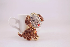 Detail of cute puppy keychain with sparkling amber rhinestones and a red enamel collar