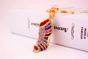 Detalle de un llavero creativo de tacón alto con diamantes de imitación de colores sobre oro
