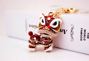 Gros plan sur un porte-clés lion chinois avec émail rouge et strass brillants